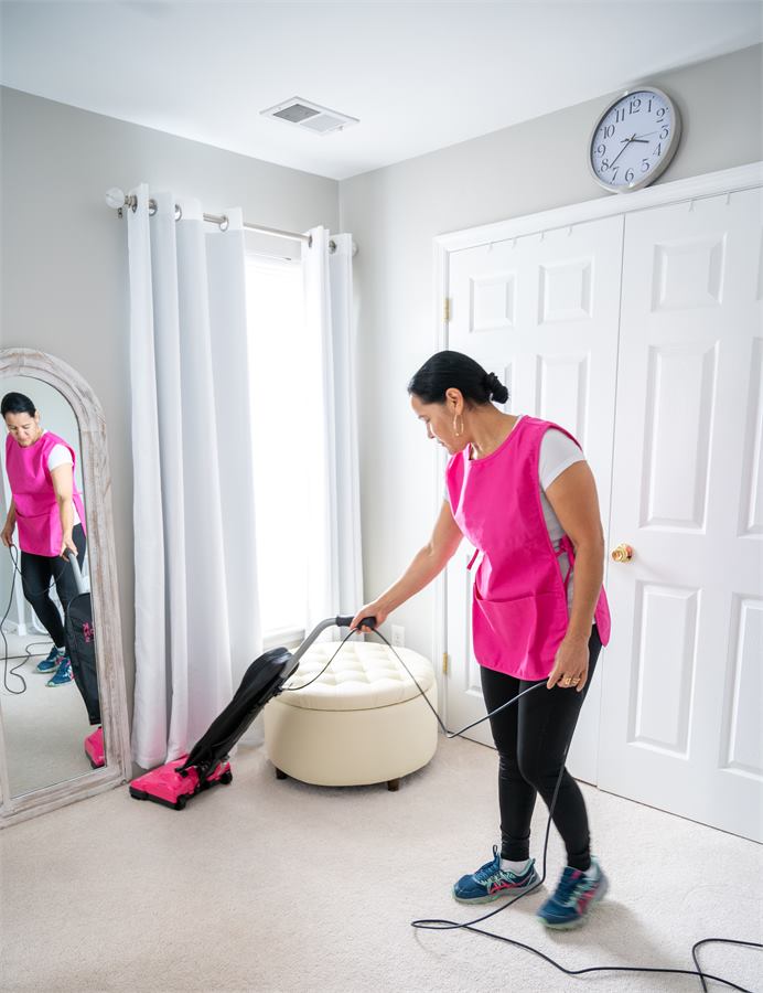 Pro Shine team member vacuuming a carpeted room